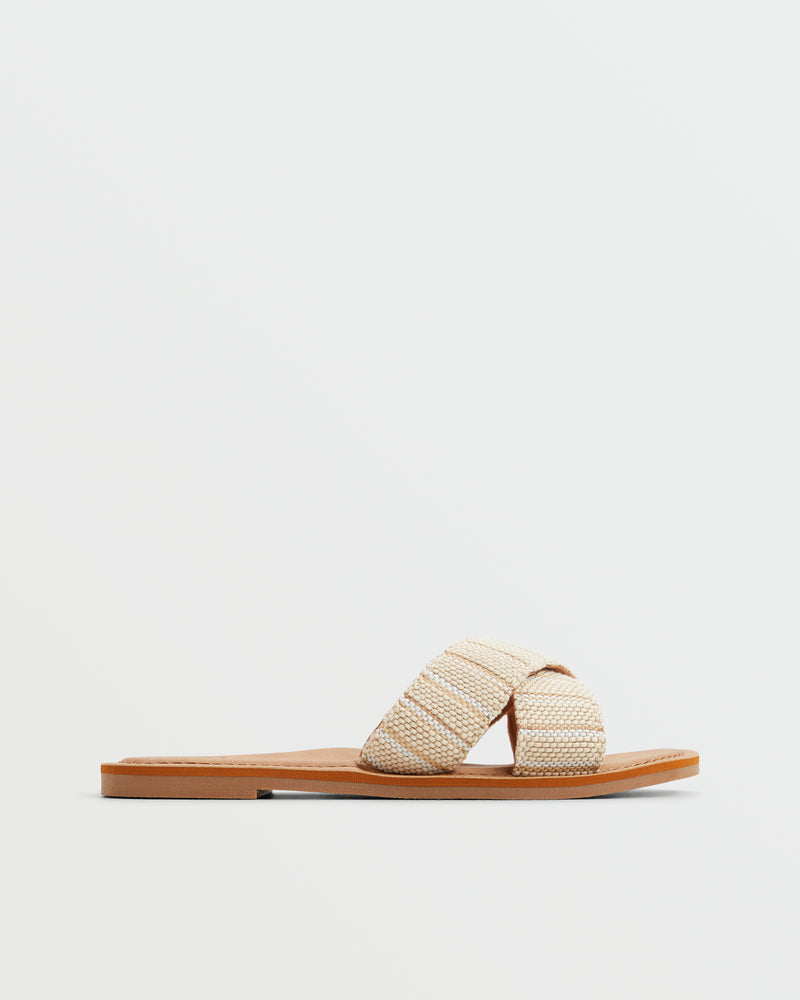 The Roxy Andreya Sandal features a tan sole and two wide, textured beige straps that crisscross, shown against a plain white background.