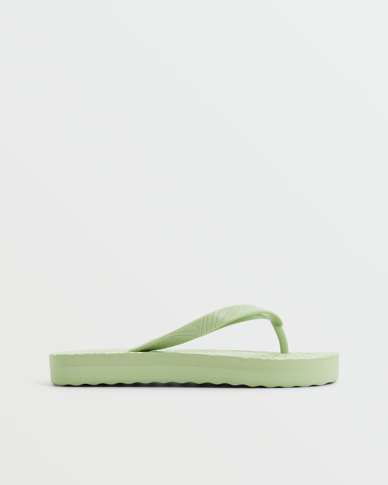 The ROXY Beach Up Sandal is a light green casual flip flop with a textured sole and simple strap, shown in side profile on a plain white background—ideal stylish footwear for the beach.