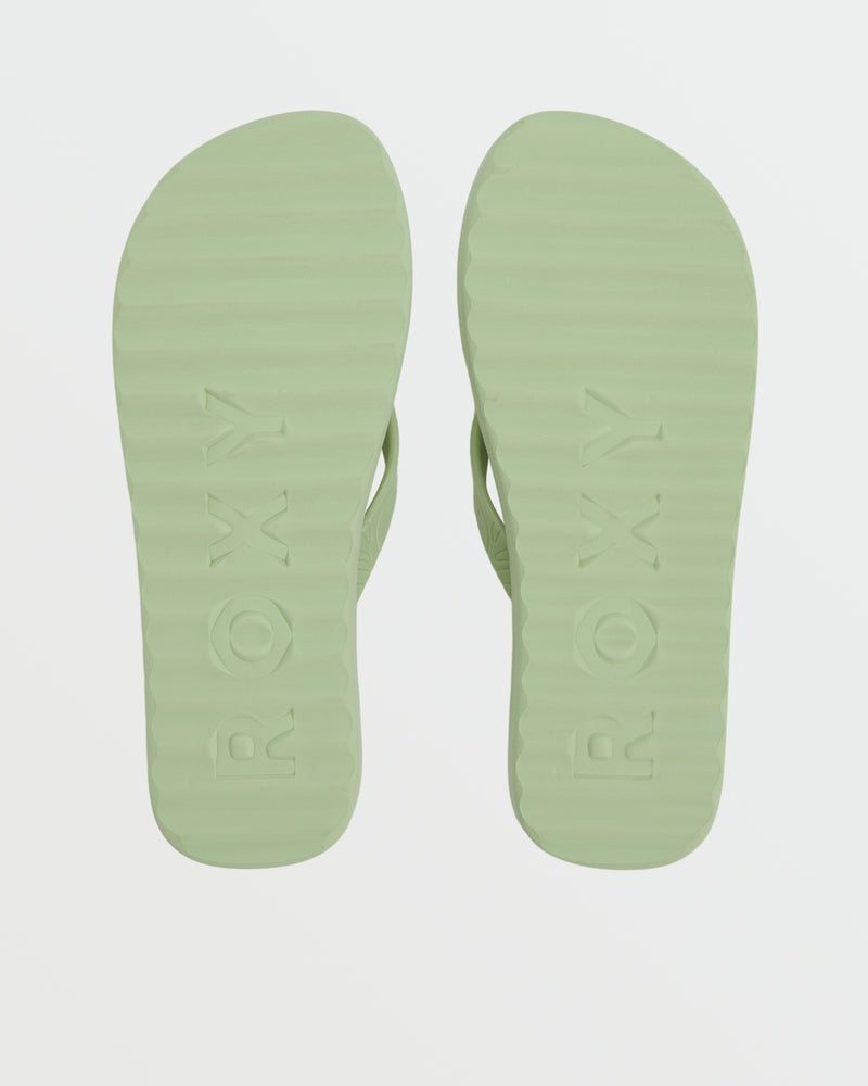 A pair of light green Roxy Beach Up Sandals viewed from the bottom, featuring "ROXY" embossed on each sole—ideal as casual flip flops or stylish beachwear.
