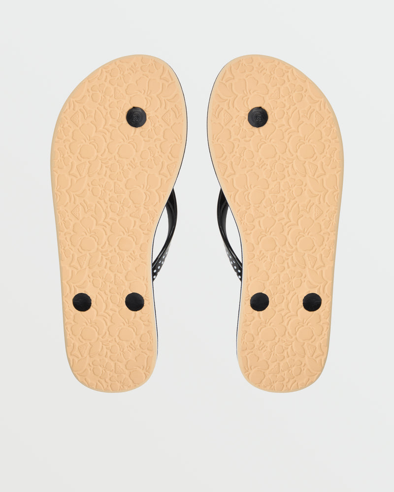 The Roxy Portofino III Sandal features comfy beige soles adorned with a floral pattern, black straps, and circular plugs—shown upside down to highlight the design. A stylish addition to your summer flip flop collection.