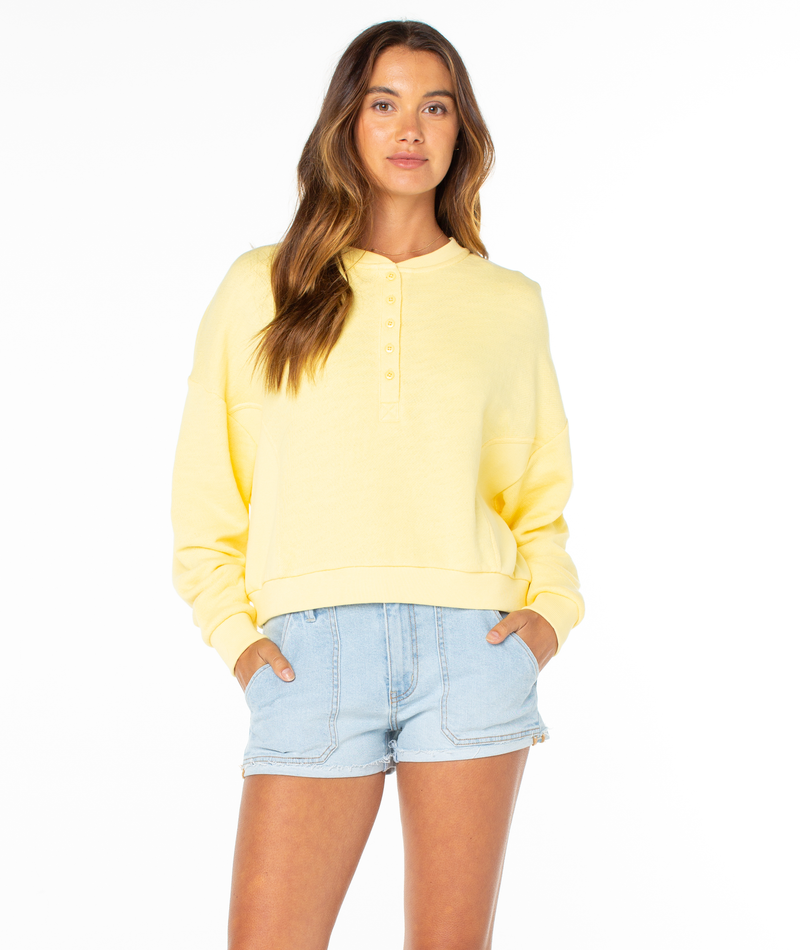 A woman with long brown hair wears the Roxy Overcast Hoodie and stands facing forward with her hands in her pockets against a white background.
