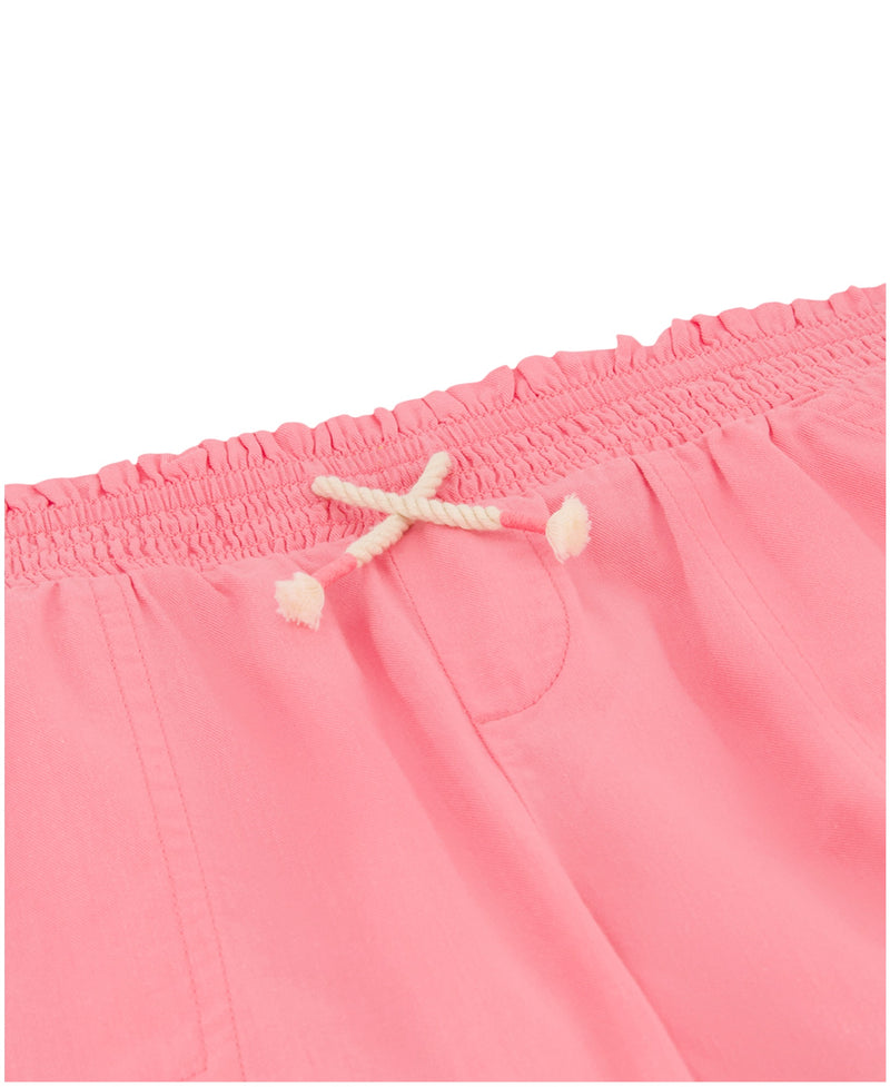 Close-up of Roxy Girls' Soleil Short in pink brushed twill, featuring a smocked elastic waistband with a cream knotted drawstring. Soft fabric, visible seams, and pocket stitching make it ideal for casual beachwear.