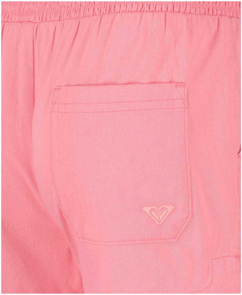 Close-up of Roxy Girls' Soleil Short in pink brushed twill. Features a back pocket with a small embroidered heart logo and a smocked elastic waistband for comfort, making these shorts perfect for beachwear.
