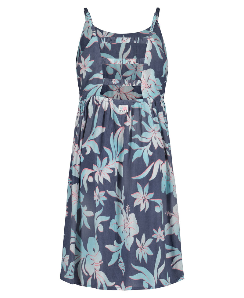 The Girls' Hibiscus Hype Dress by Roxy is a sleeveless, knee-length fit and flare dress with thin straps, a gathered waist, cutout bodice, and features a blue background with light pink and white tropical floral print.
