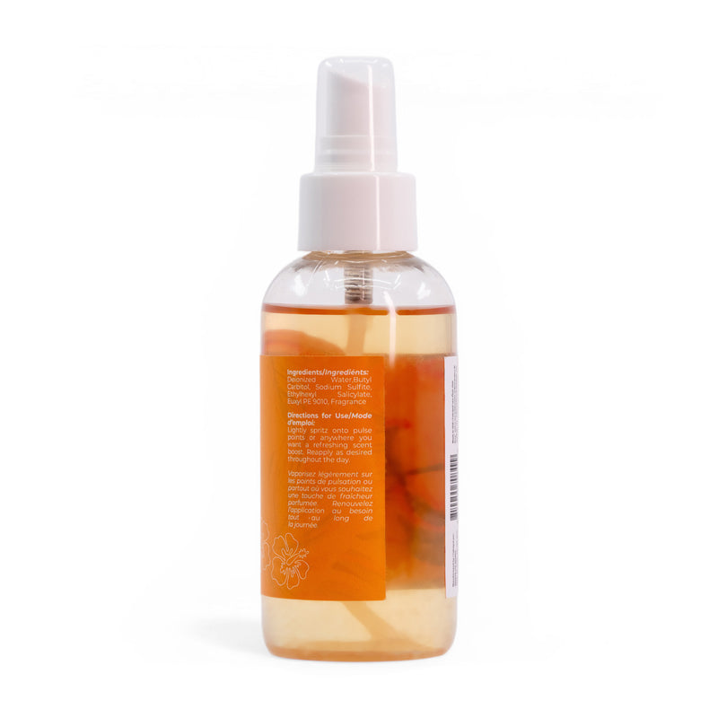 A clear plastic spray bottle of Roxy Sun Drift Body Mist with an orange label and white cap, filled with yellow liquid. The label shows guava and hibiscus graphics, ingredients, and directions, though most text is unreadable from this angle.