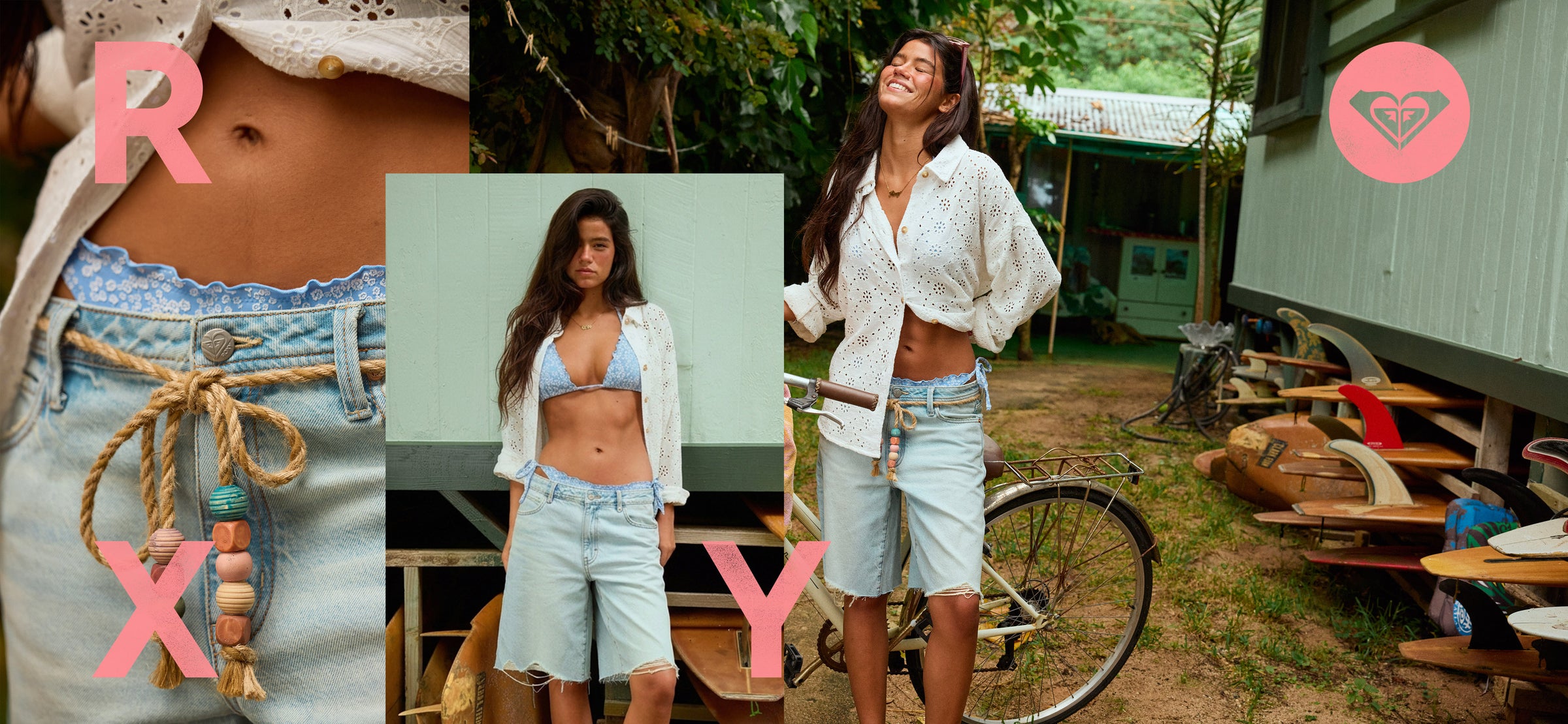 Woman in a white shirt and denim shorts standing outdoors with a bicycle and wooden structures in the background.