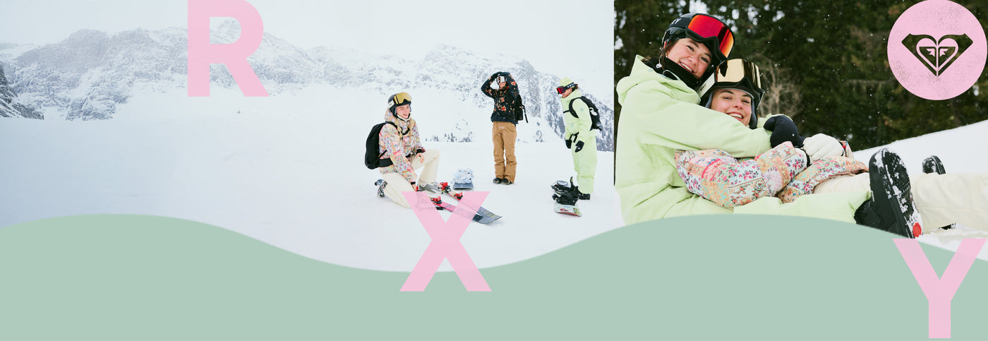 women in snow gear on top of a snowy mountain laughing 