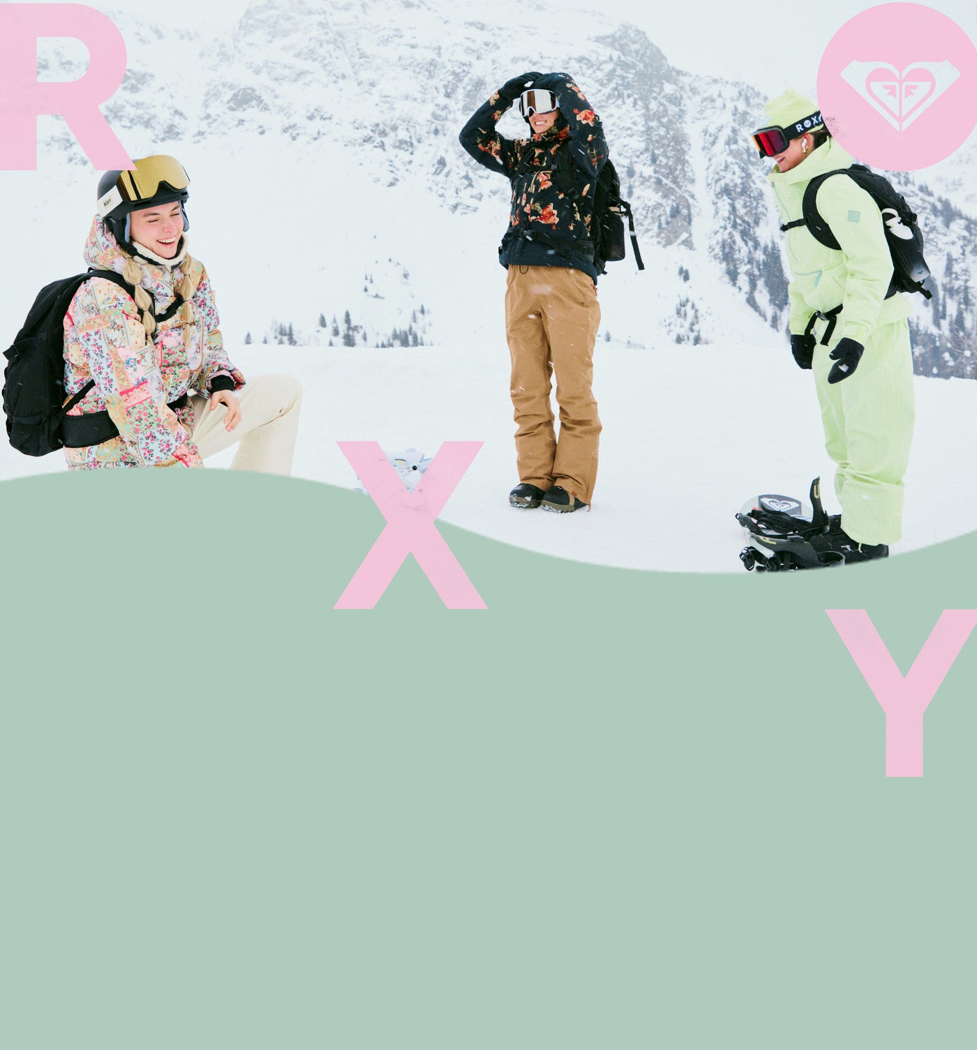 women in snow gear on top of a snowy mountain laughing 