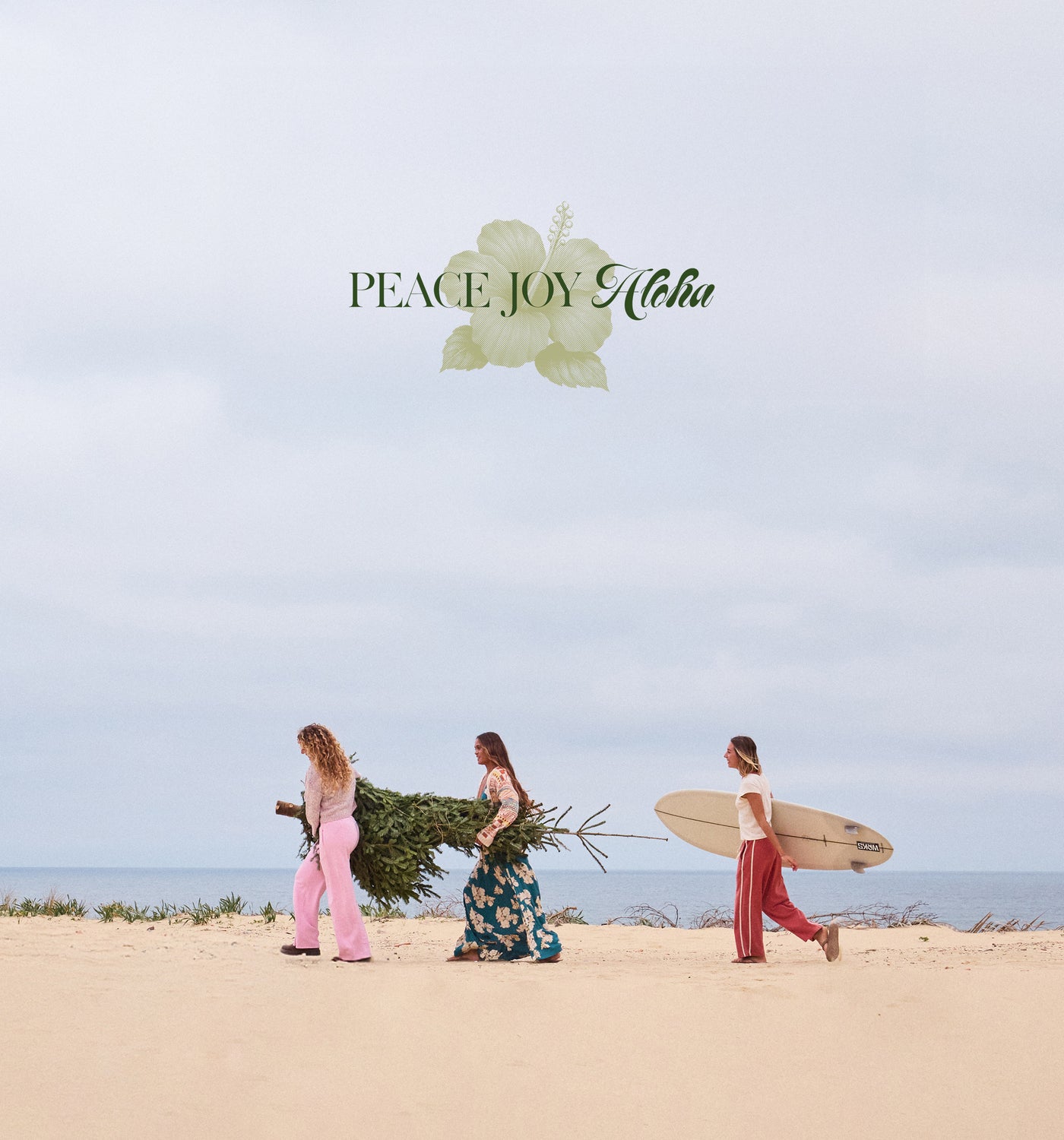 Three people walking on a beach with surfboards and a Christmas tree, under the text 'Peace Joy Aloha'.