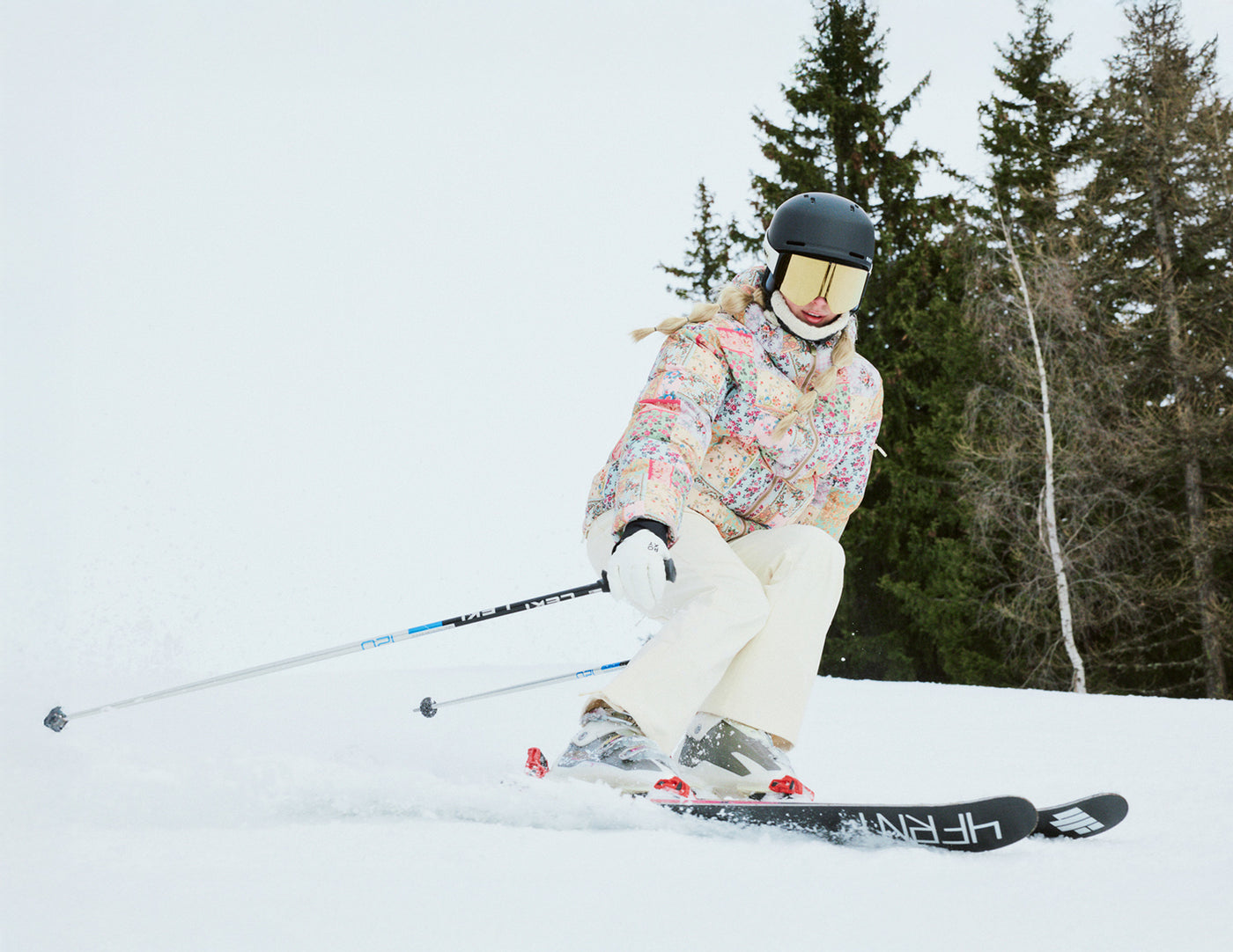 Person skiing on a snowy slope with trees in the background