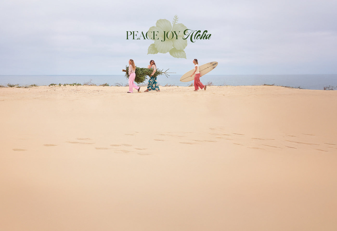Three people on a sandy beach with surfboards and flowers, featuring 'Peace Joy Aloha' text.