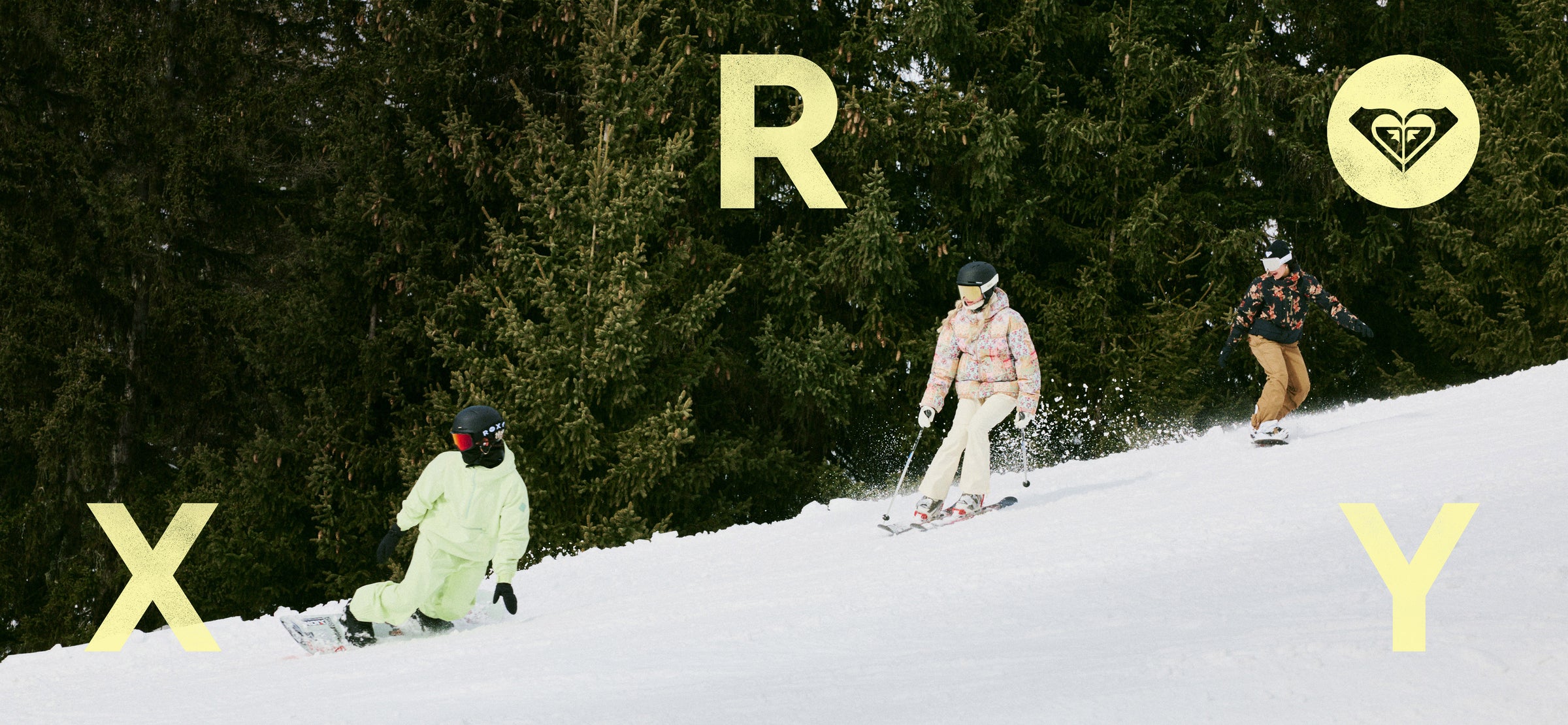 Three people snowboarding down a hill with 'Roxy' branding in the background.