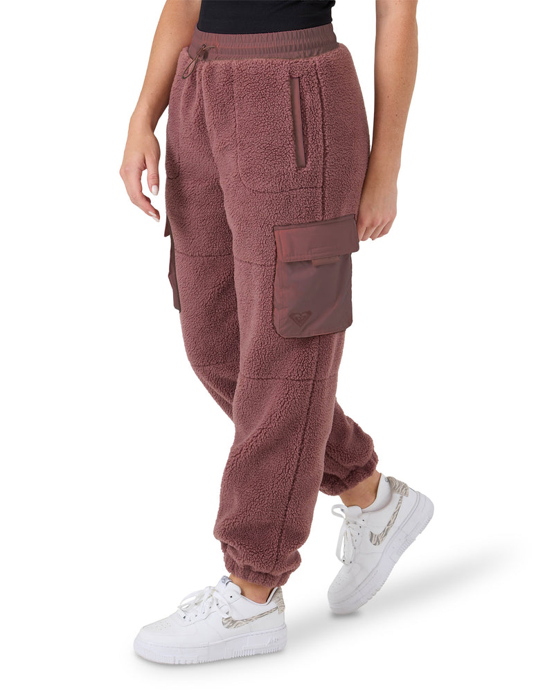 Burgundy Rita Sherpa Jogger pants with cargo pockets and a drawstring waist, worn with white sneakers.