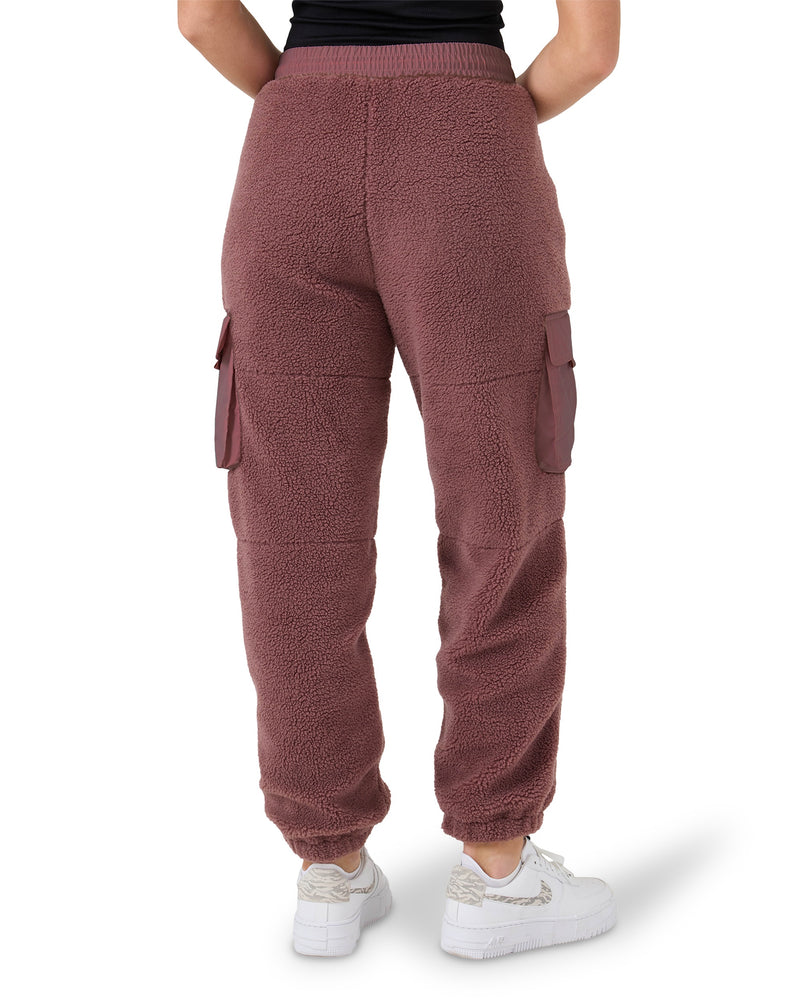 Rear view of a person wearing burgundy Rita Sherpa Joggers featuring side cargo pockets and elastic cuffs.