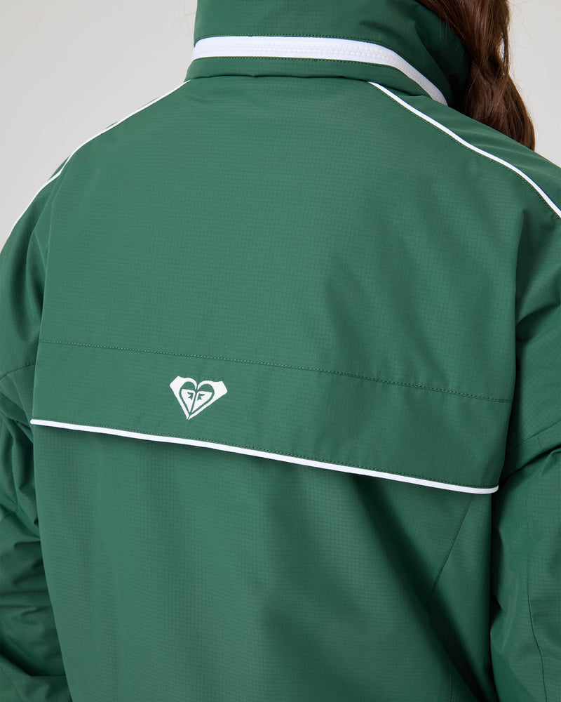 Person wearing the Roxy Emily Track Jacket in green with white piping and a small white heart-shaped logo on the back. Only the upper back and part of an arm are visible.