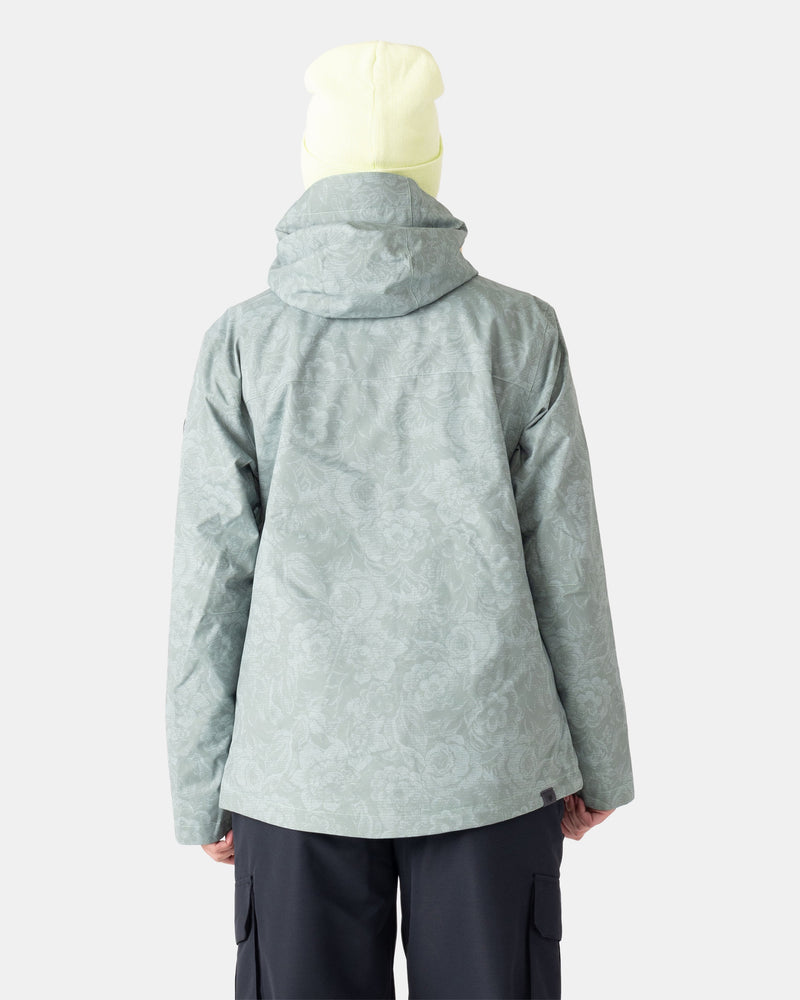 A person is shown from the back against a plain white background, wearing the Roxy Jetty 3N1 women’s snowboard jacket in a light green pattern with a hood and a pale yellow beanie.