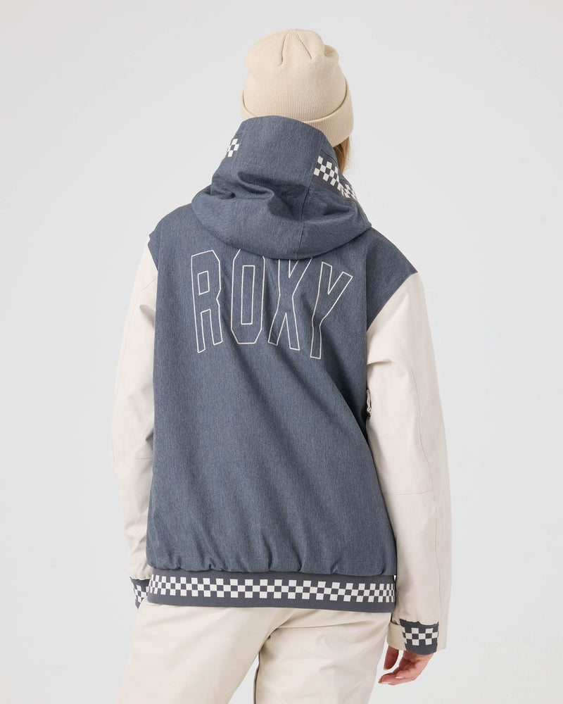 A person stands against a plain light background wearing the Roxy Cheer Up Jacket—a women’s snow jacket with ROXY text on the back, cream sleeves, checkered trim, and a cream beanie. This technical outerwear features a 10K/10K shell for dependable protection during winter adventures.