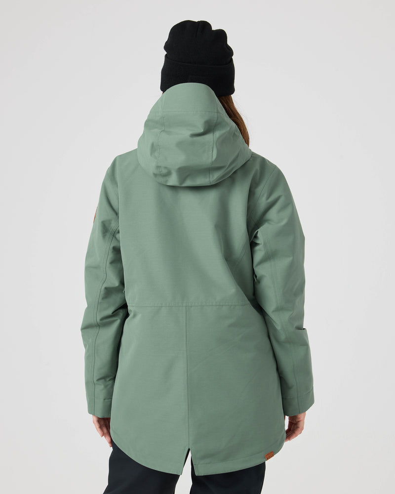 A person wearing the Roxy Free Love Jacket in sage green with PrimaLoft insulation and a black beanie stands facing away, showcasing the back design of the jacket against a plain white background.