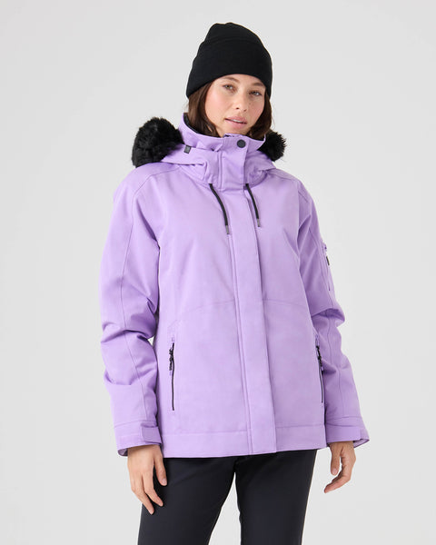 A person wearing the Roxy Meade Jacket in Sunlit Allium—a lilac women’s snow jacket with a hood, black fur trim, 10K protection, and a tailored fit—is paired with a black beanie and black pants, standing against a plain light gray background.
