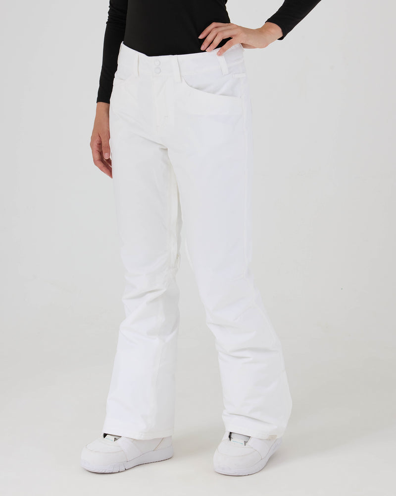 A person wearing a black long-sleeve top and the Roxy Backyard Pants in white, crafted from recycled polyester, stands with one hand on their hip, showing only their lower body against a plain white background. The women’s snow pants provide reliable 10K/5K protection for comfort and durability in wintry conditions.