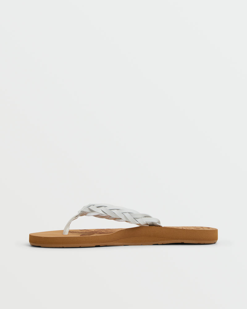 The Roxy Feel Breezie Sandal features a brown flat sole and white braided thong strap, shown on a plain white background—ideal for anyone seeking comfortable sandals or stylish beach flip flops.