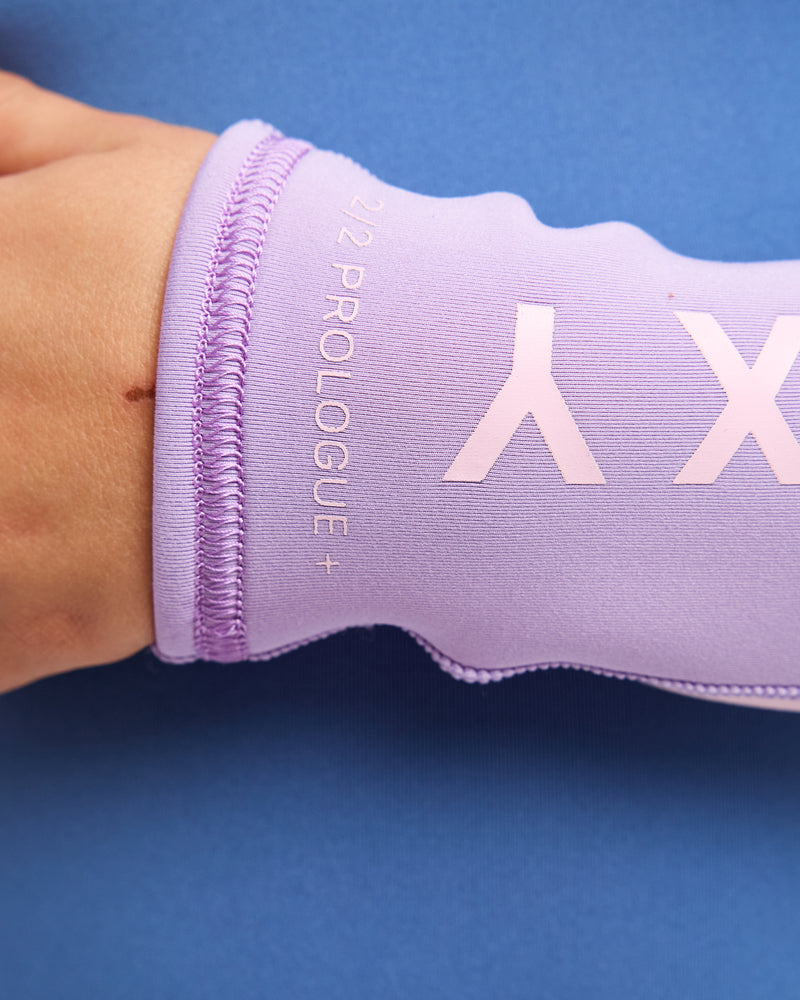 Close-up of a lilac long-sleeved Roxy 2/2mm Prologue Girls’ Long Sleeve Wetsuit wrist cuff, showing the text 2/2 PROLOGUE+ printed near the hem.