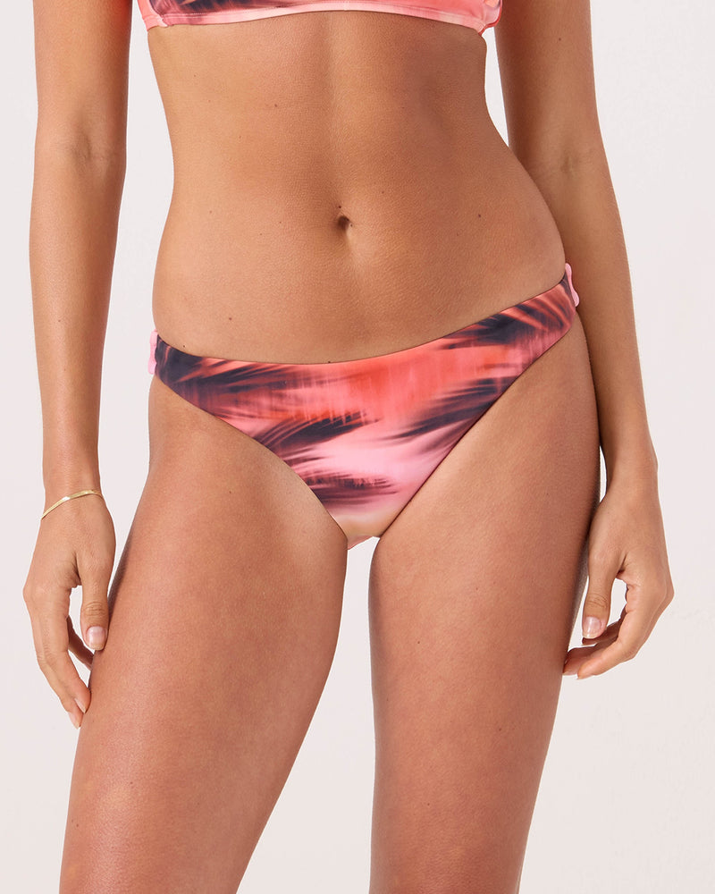 A woman wears the Roxy Palm Before The Storm Hipster Moderate Bikini Bottom in Blkcoral, showing only her torso and upper legs against a plain light background.