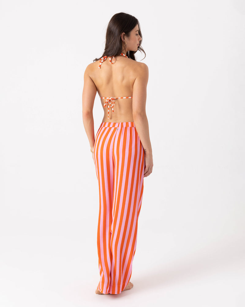 Viewed from behind, a person wears a striped orange and pink bikini top with matching Roxy Ya Stripe Me Crazy Beach Pant, which feature a drawcord elastic waist.