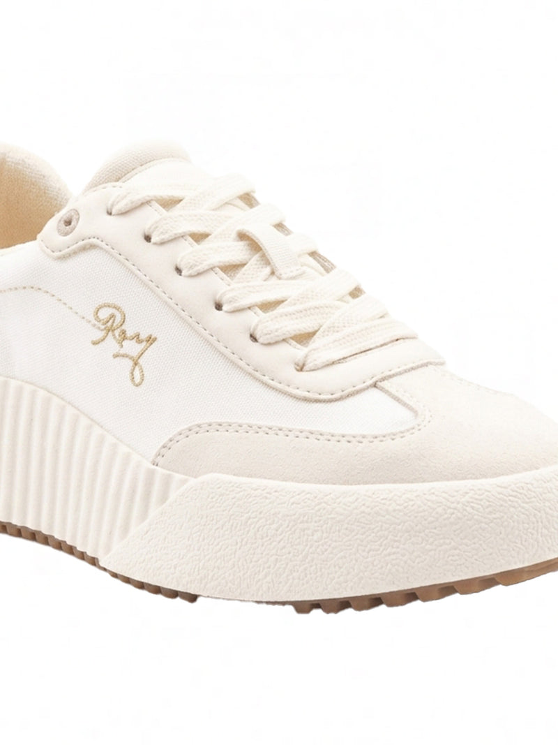 The Bling Sneaker by Roxy is a white shoe with a thick, textured sole, white laces, gold Roxy branding on the side, and a modern minimalist design.
