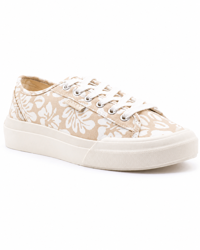 The Roxy Marina Sneaker for women features beige canvas with white floral patterns, white laces, metal eyelets, and a thick white rubber sole, shown from a slight angle on a white background.