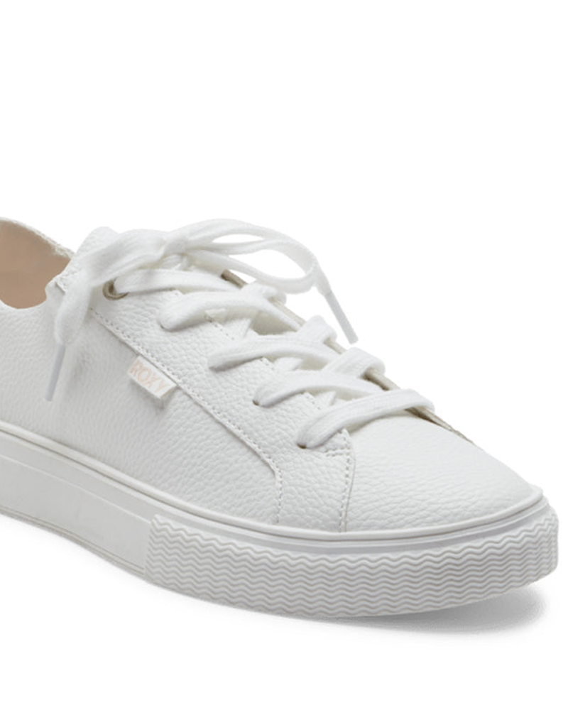 The Roxy Coral Tides Sneaker is a white low-top with textured material, white laces, and a thick white rubber sole.