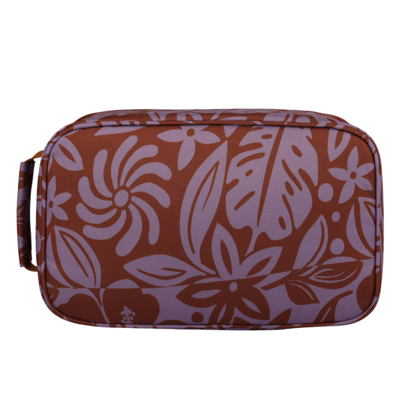 The Groovy Life Lunch Bag by Roxy is a rectangular bag with a handle, showcasing a brown and lavender floral pattern with various tropical leaves and flowers.