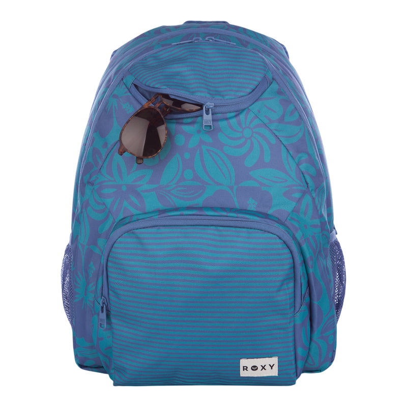 A blue floral-patterned Shadow Swell Backpack by Roxy, featuring a front zip pocket, two mesh side pockets, and sunglasses hooked onto the top zipper.