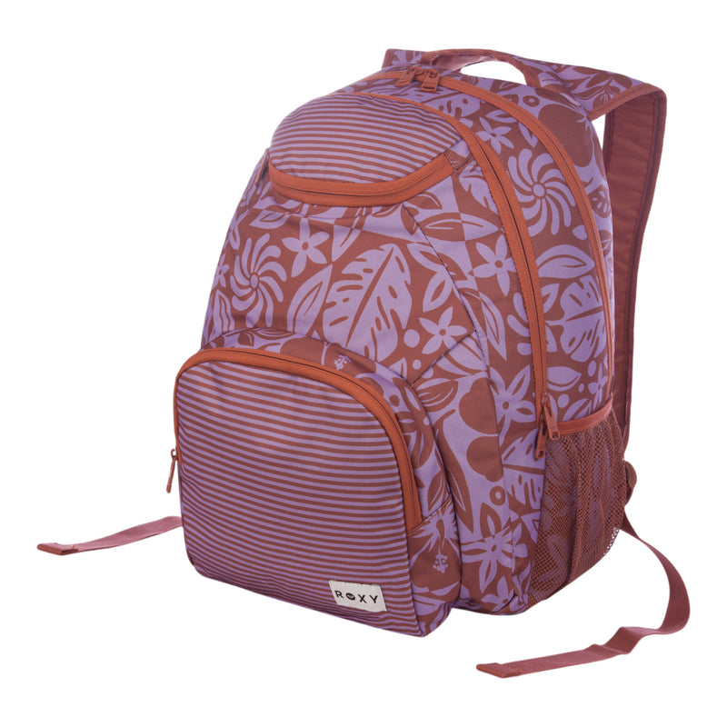 The Roxy Shadow Swell Backpack features a purple and pink floral pattern with stripes, a front zip pocket, mesh side pocket, adjustable straps, and a ROXY label on the front. The design showcases hibiscus-style flowers.