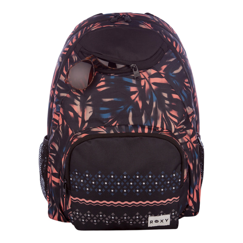 The Roxy Shadow Swell Backpack showcases dark hues with vibrant pink and blue leaf and geometric patterns. It features a front zip pocket, mesh side pockets, and a small top pocket perfect for stashing sunglasses.