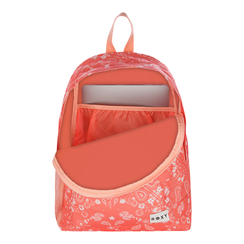 The Roxy Sugar Baby Bottle Backpack features a coral pink color with a white paisley pattern. A front zipper pocket is partially open, revealing an inner compartment equipped with a laptop sleeve, while the Roxy brand label is visible at the bottom.