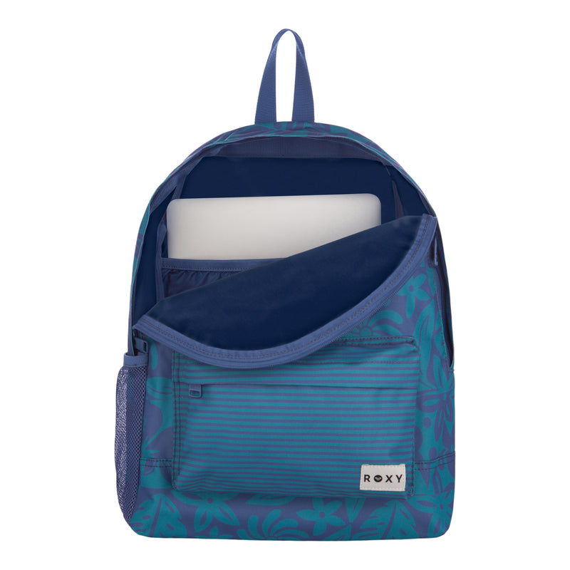 The Roxy Sugar Baby Bottle Backpack features a blue floral design with a front pocket, partially unzipped to show a laptop inside. A mesh side pocket is visible, and the ROXY logo appears on the front pocket.