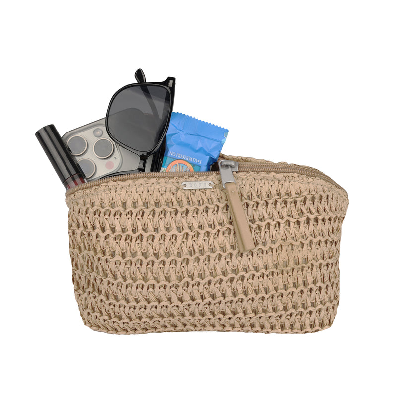The Roxy Spotless Sunnies Fanny Pack in beige features a woven design and a zippered opening, partly open to reveal sunglasses, a smartphone, a blue packet, and a tube of lipstick inside.