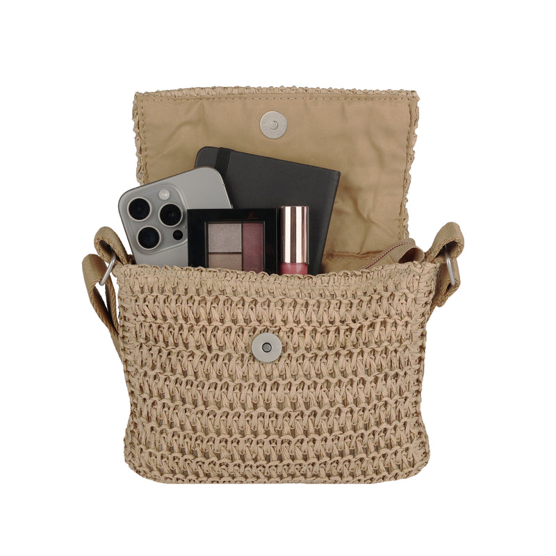 The Roxy Spotless Sunnies Crossbody Bag is a beige woven bag with an adjustable strap and magnetic flap, roomy enough for a smartphone, black notebook, eyeshadow palette, and lipstick.