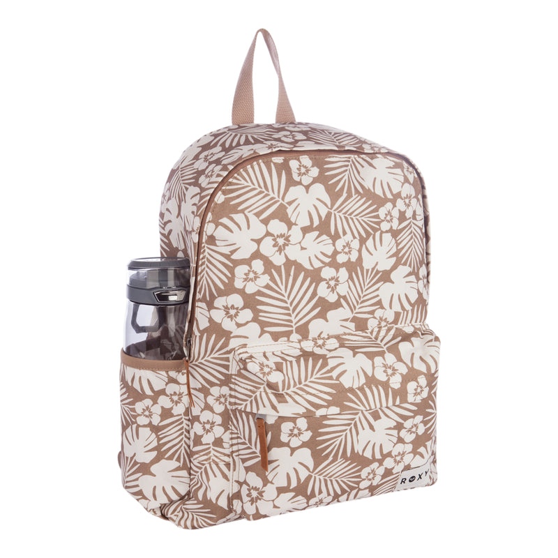 The Sugar Baby Canvas Backpack by Roxy features a beige design with a white tropical floral print. It includes a front pocket, a side pocket perfect for holding a water bottle, a top handle, and secure zipper closures. The Roxy brand logo is displayed on the lower front corner.