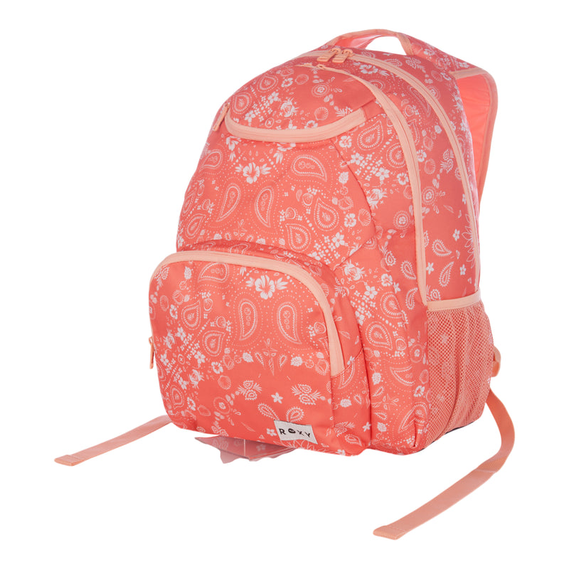 The Roxy Shadow Swell Backpack features a coral pink color with a white paisley and floral pattern, front and side pockets, and light pink zippers and straps.
