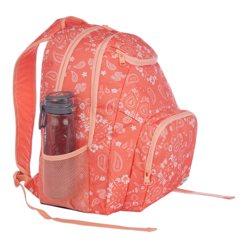 The Roxy Shadow Swell Backpack is shown against a white background, featuring a coral color with white paisley patterns. It has three zippered compartments and a mesh side pocket holding a water bottle.