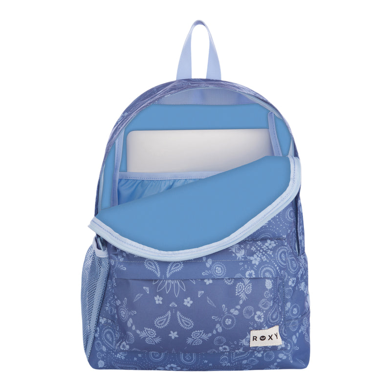 The Roxy Sugar Baby Bottle Backpack features a blue patterned design with a light blue zipper, shown partially unzipped to reveal a laptop inside the main compartment. It includes a front pocket, a mesh side pocket, and a small ROXY label at the bottom right corner.