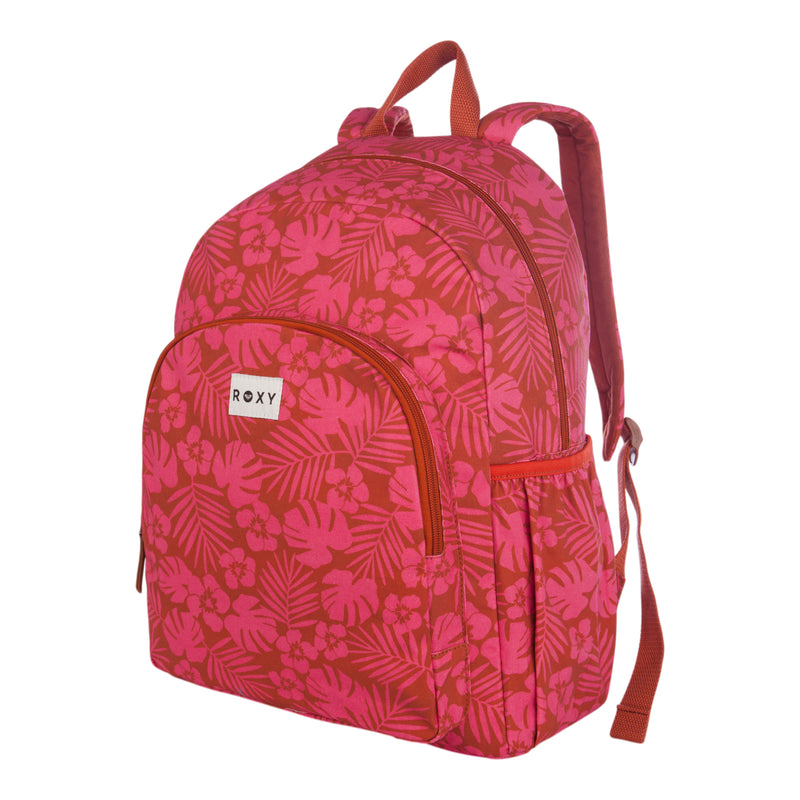 The Roxy Moon Magic Backpack features a pink and red floral pattern, front zipper pocket with the Roxy logo, side pocket, and a convenient carrying handle.