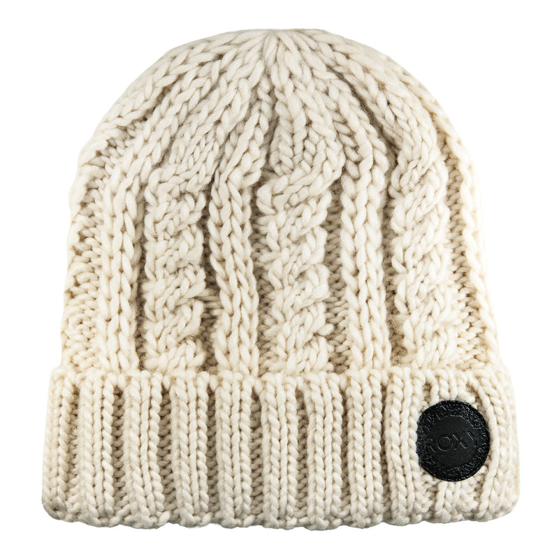 The Roxy Tram Beanie is a chunky cable knit women’s hat in buttercream, featuring a cozy fold-over brim, warm fleece lining, and finished with a black circular patch on the front.