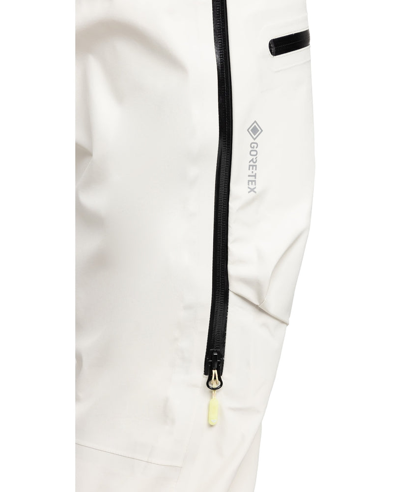 Close-up of the Roxy Gore-Tex 3L Lunalite Bib, a women’s snow bib in white crafted from GORE-TEX 3L fabric, featuring a black waterproof zipper with a yellow pull tab and a small black horizontal pocket above the zipper for enhanced waterproof and breathable protection.