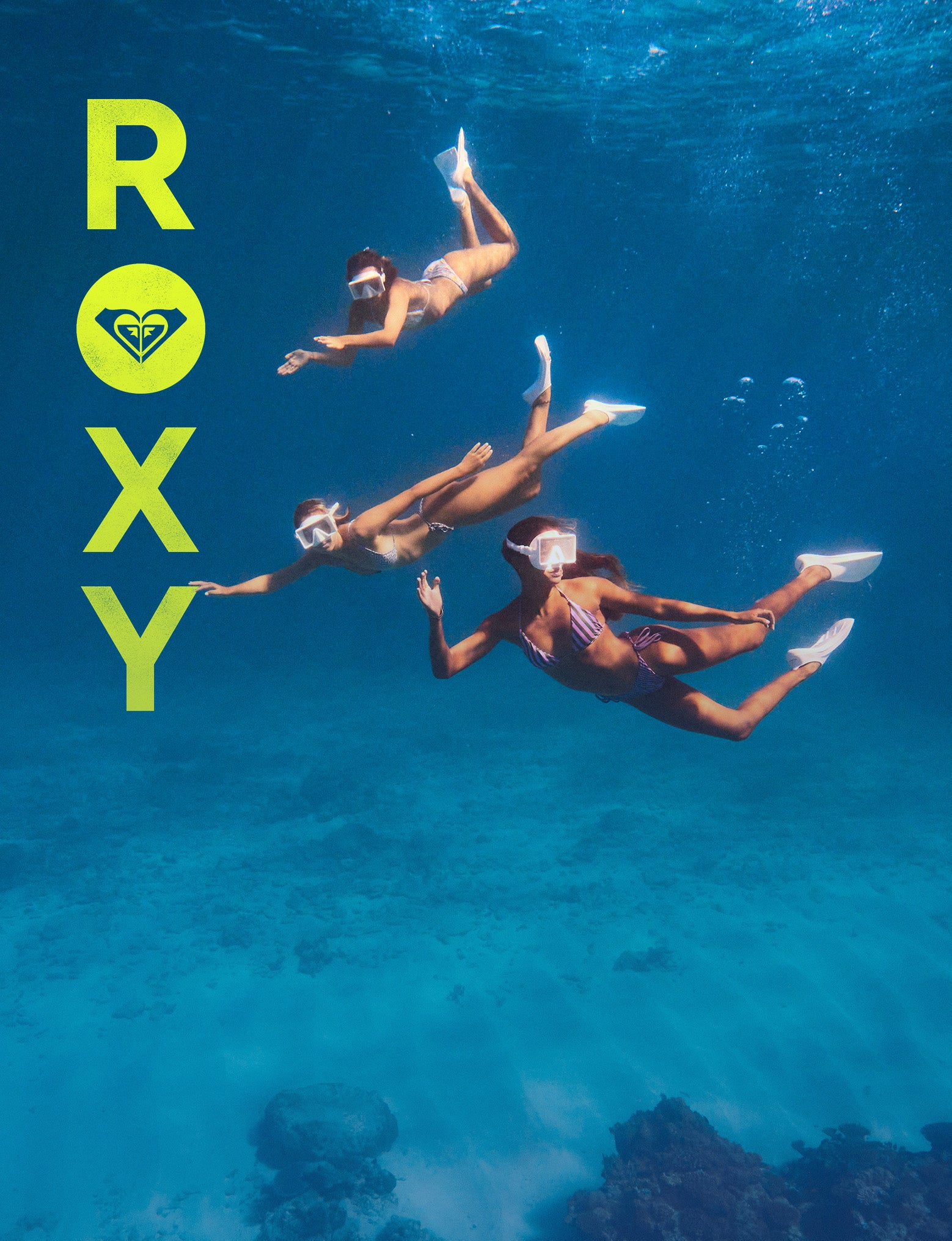 Three people snorkeling underwater with Roxy logo on a blue background