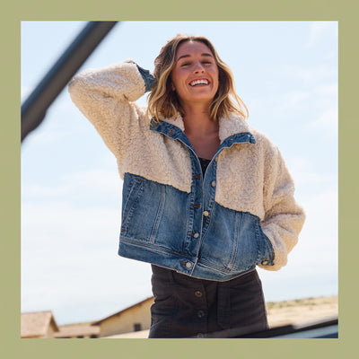 Woman wearing a denim jacket with a sherpa lining, standing outdoors