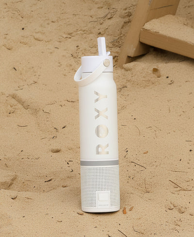 White water bottle with 'ROXY' branding on a sandy background