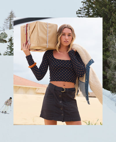 Woman carrying a large wrapped gift outdoors with trees in the background